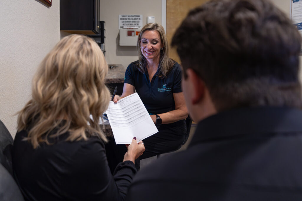 A medical professional smiles while discussing a couple's treatment plan at a medical weight loss clinic near you in Clearwater