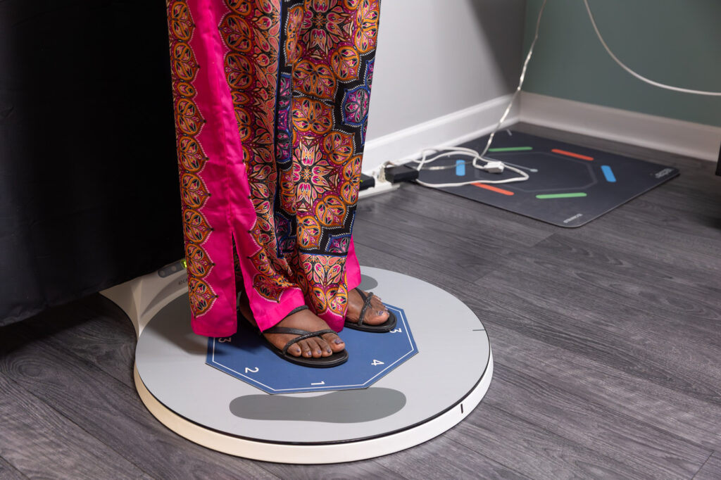 A female patient stands on a medical device to inform her plan for body shaping in St. Petersburg