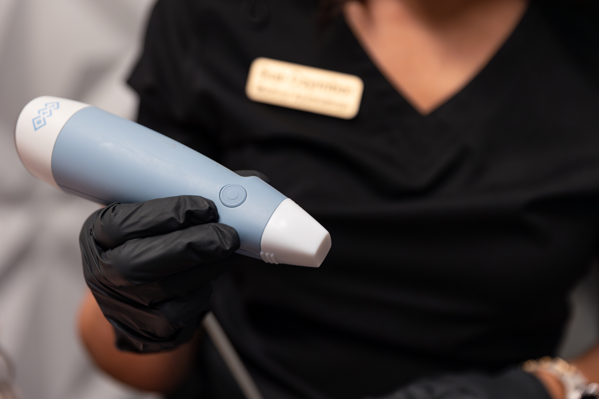 A professional in scrubs prepares a microneedling device for a patient's hair restoration in St. Petersburg